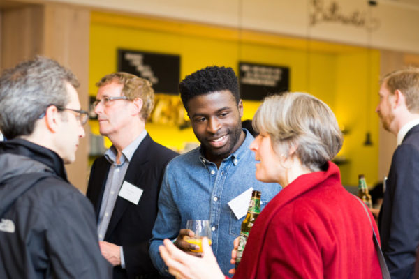 Three people discussing at a drinks reception