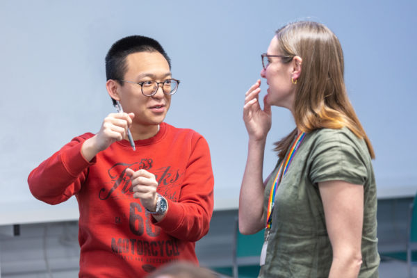 Two people discussing, one with a pen in their hand