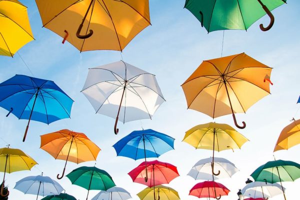 Colourful umbrellas floating in a blue sky