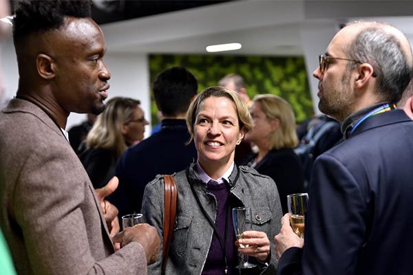Three people talking at a reception event